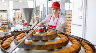 Conveyor belt in a bakery with newly baked buns