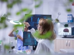 Female scientist holding and looking at a sample of liquid in a test tube. Academic scientist.