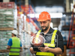 professional-manager-man-employee-using-tablet-check-stock-working-warehouse-worker-wearing-high-visibility-clothing-hard-hat-helmet-checking-count-up-goods-boxes-delivery-1-scaled