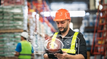 Professional manager man employee using tablet check stock working at warehouse. Worker wearing high visibility clothing and a hard hat, helmet and checking and count up goods or boxes for delivery.