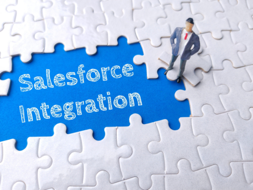 Miniature businessman on a white puzzle with text Salesforce Integration.