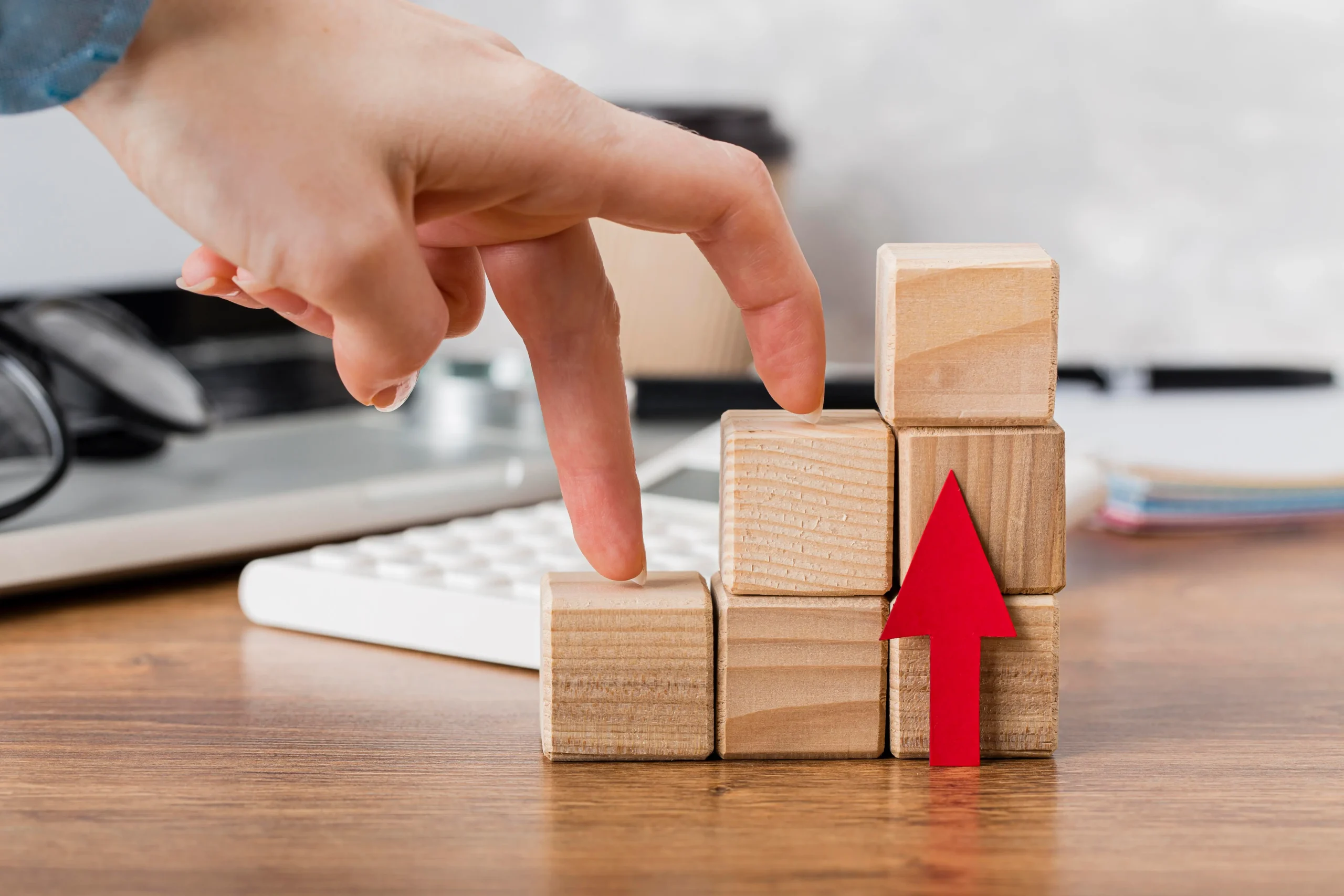 Hand climbing wooden blocks, representing growth