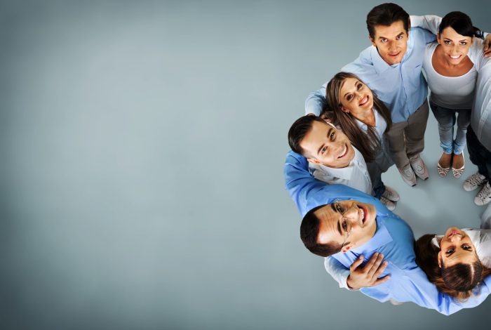 Group of smiling multi-ethnic colleagues standing in circle