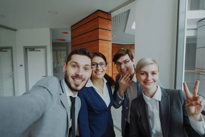 pov-happy-business-team-taking-selfie-portrait-smartphone-camera-posing-group-photo-scaled